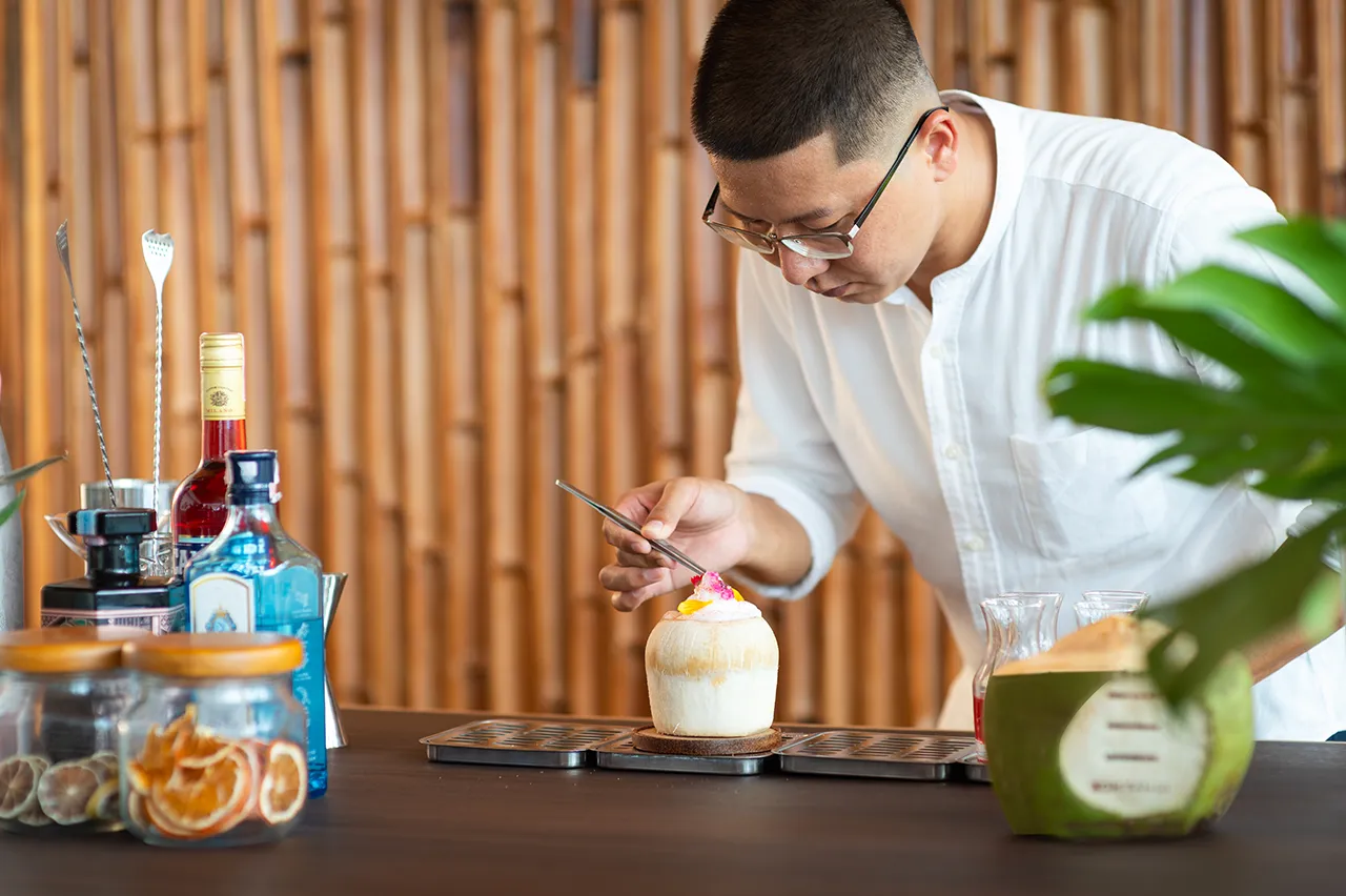 Joey Lai, Director of Mixology at Explorar Hotels, crafts a sustainable cocktail, showcasing his dedication to zero-waste practices and local sourced ingredients.