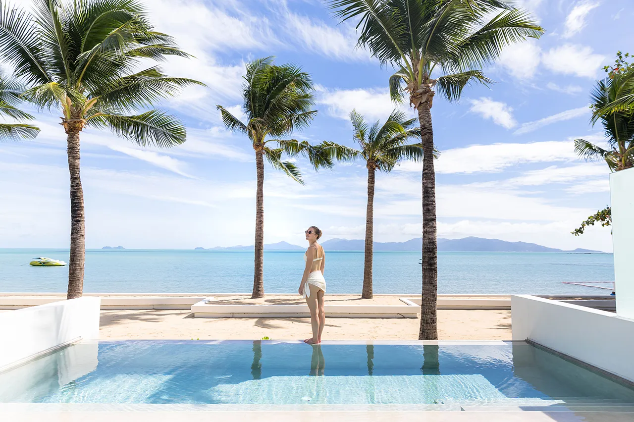 Young woman admiring the serene beach view from her private pool in the Beach Pool Villa at Explorar Koh Samui.